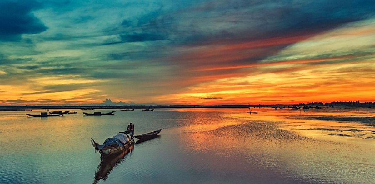 Canoa flotando en el gran río al atardecer