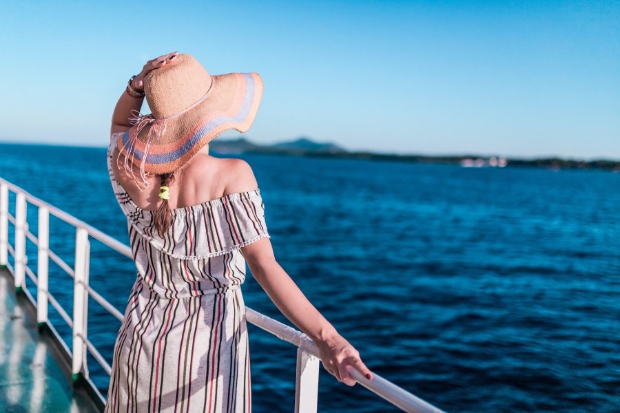 Mujer single viendo el horizonte desde la cubierta del barco