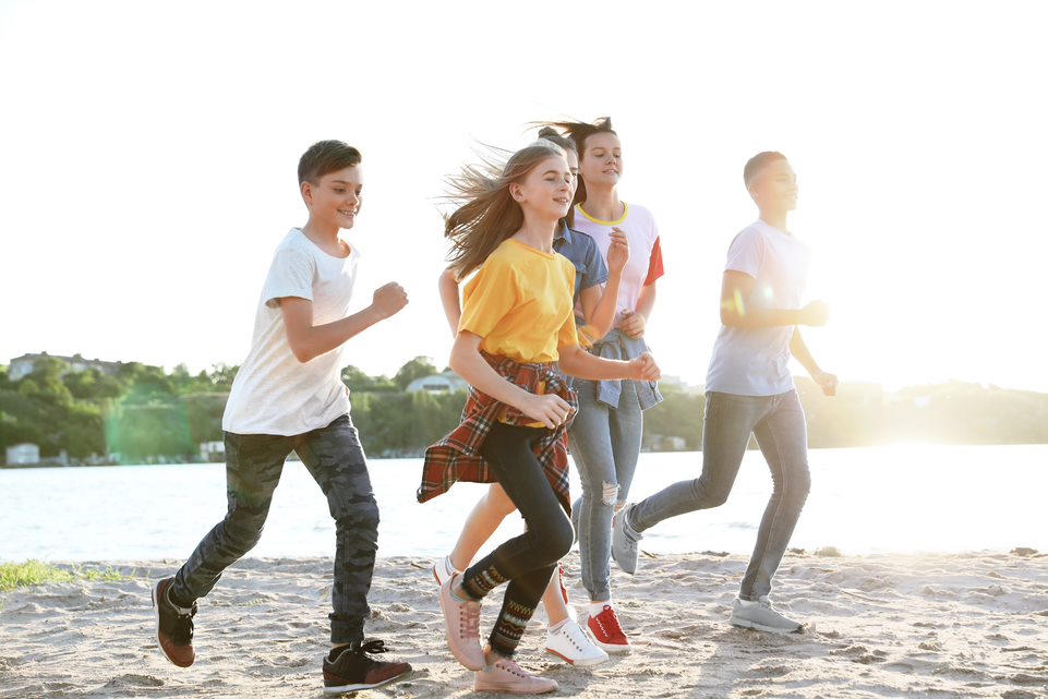 Adolescentes corriendo por la playa