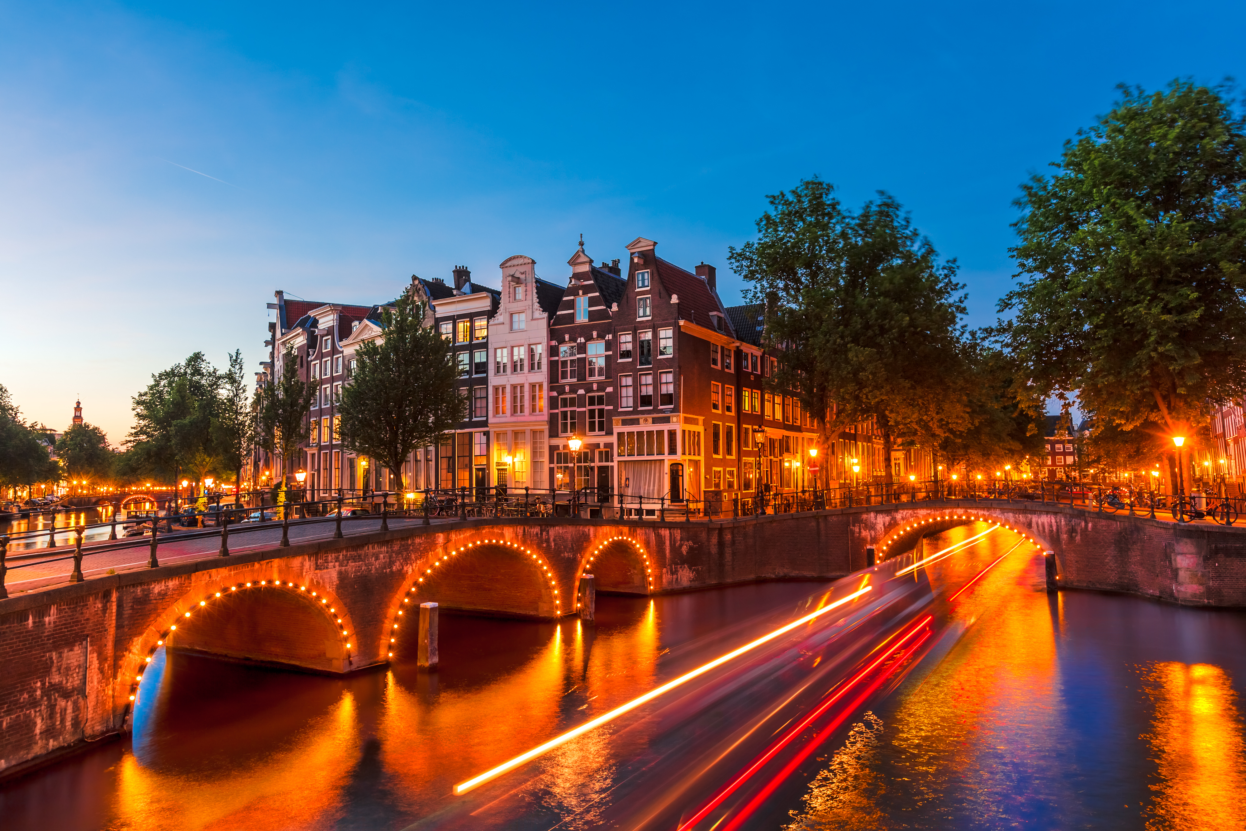 Anocheciendo en un canal en Ámsterdam decorado con luces