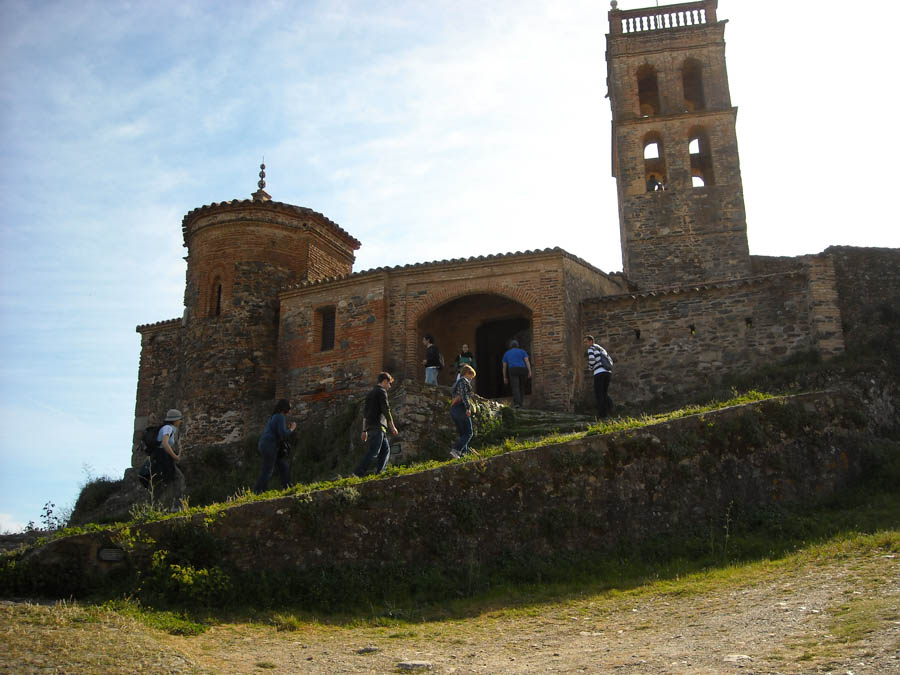 Grupo de gente subiendo a la entrada de un castillo en el pico de la montaña