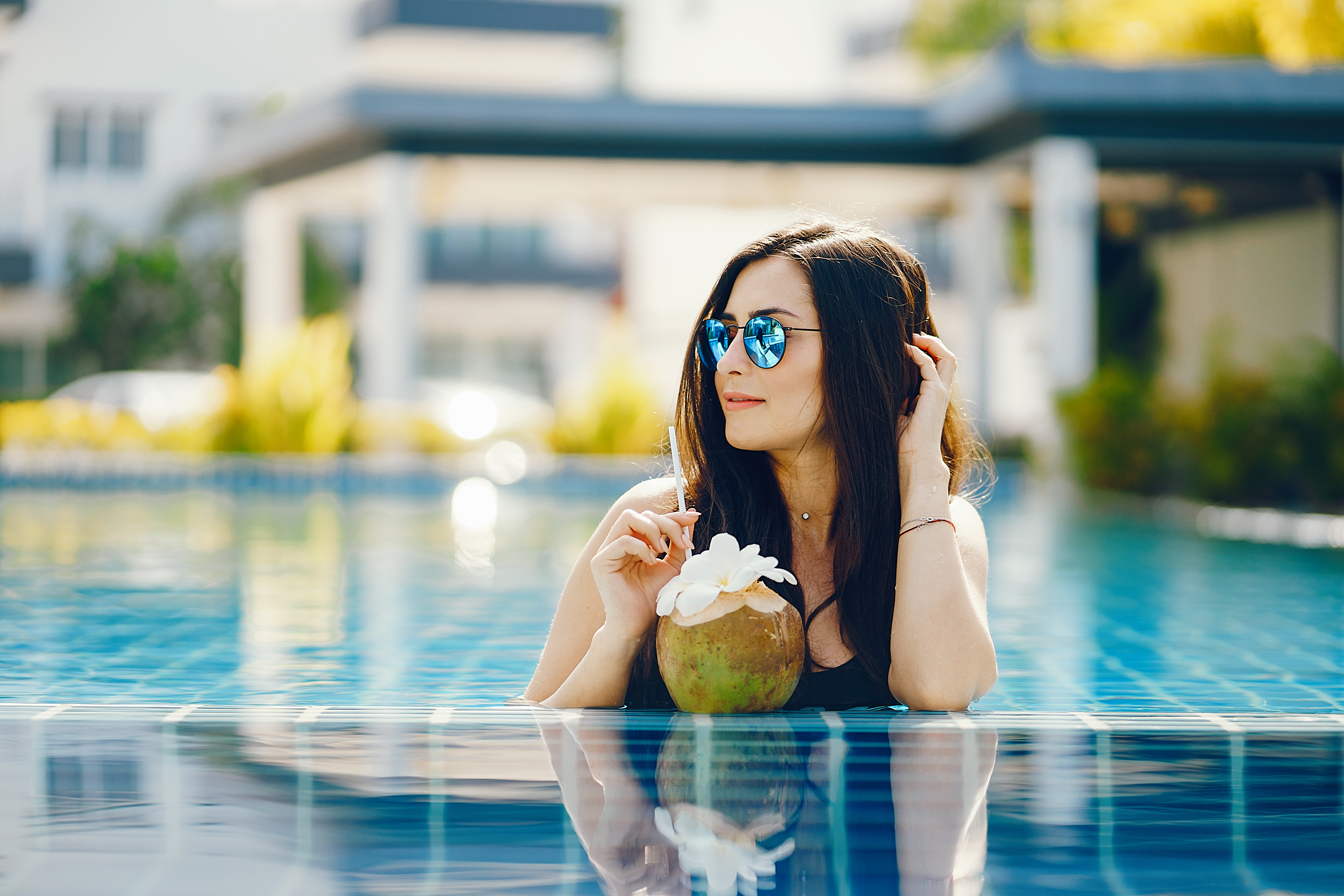 Chica single relajada en la piscina del hotel