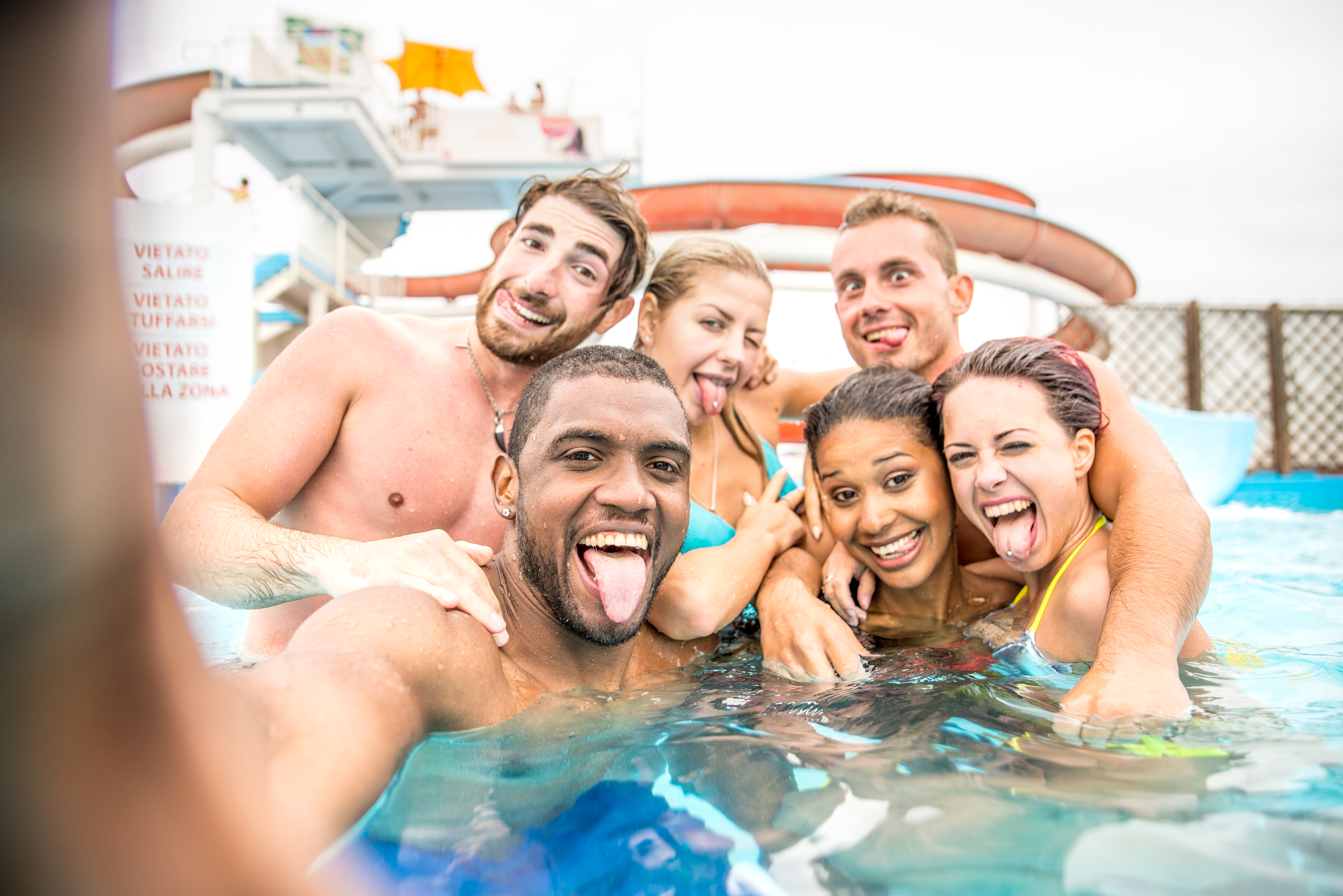 Amigos singles divirtiéndose en la piscina del crucero