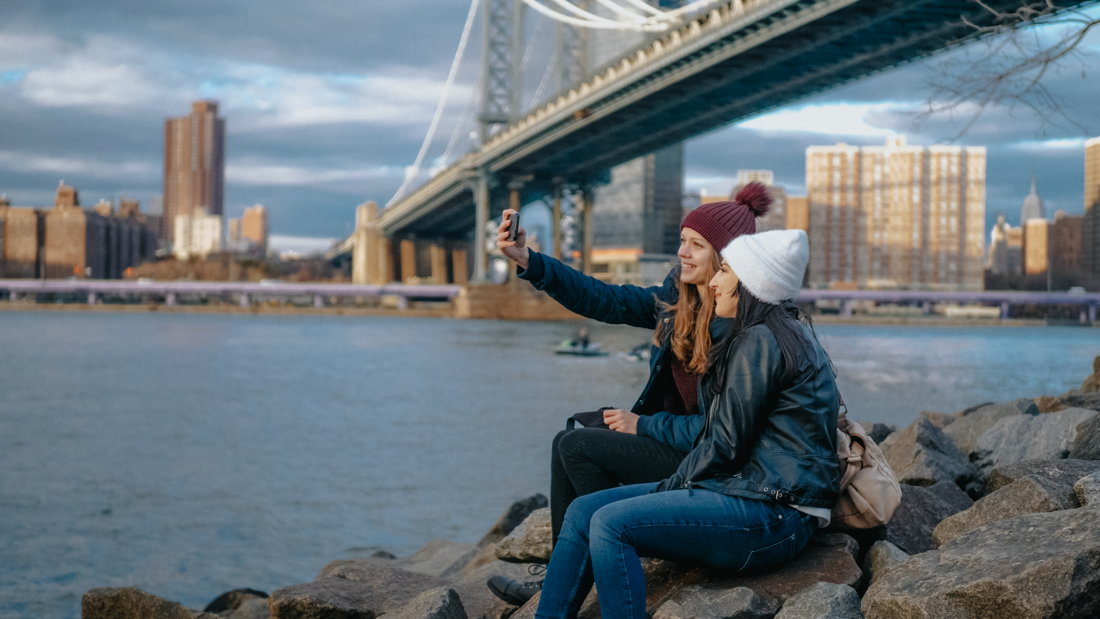 Mujer sentada junto al puente de Broklyn