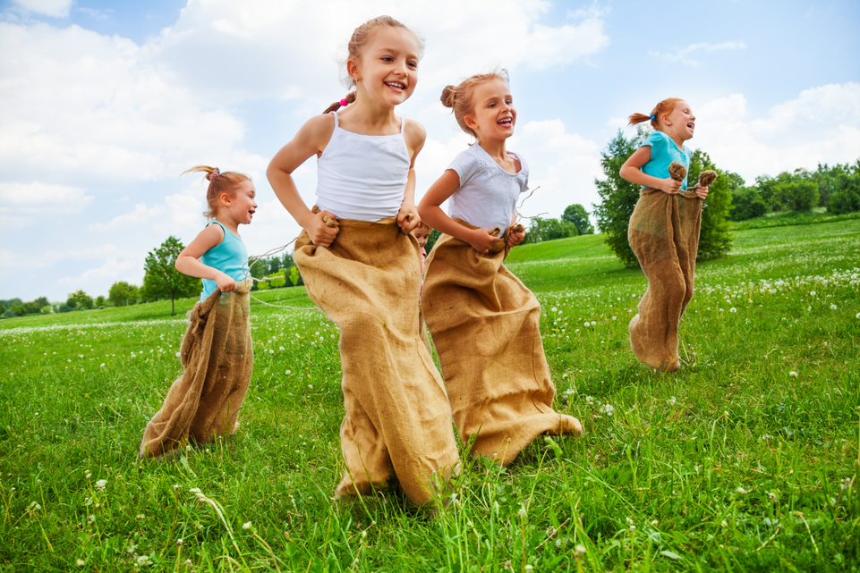 Cuatro niñas jugando a la carrera de sacos