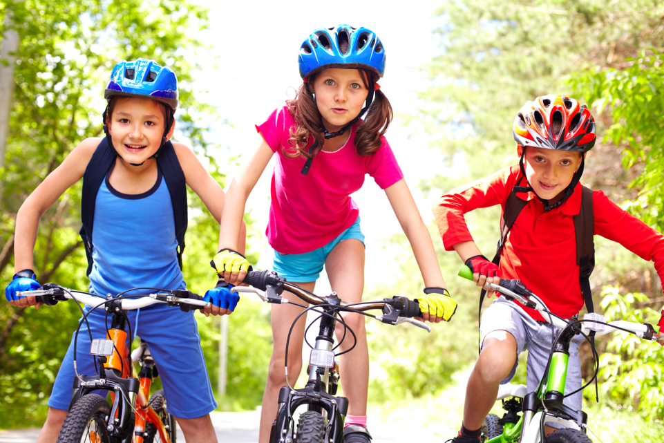 Niños montados en bici con sus cascos puestos