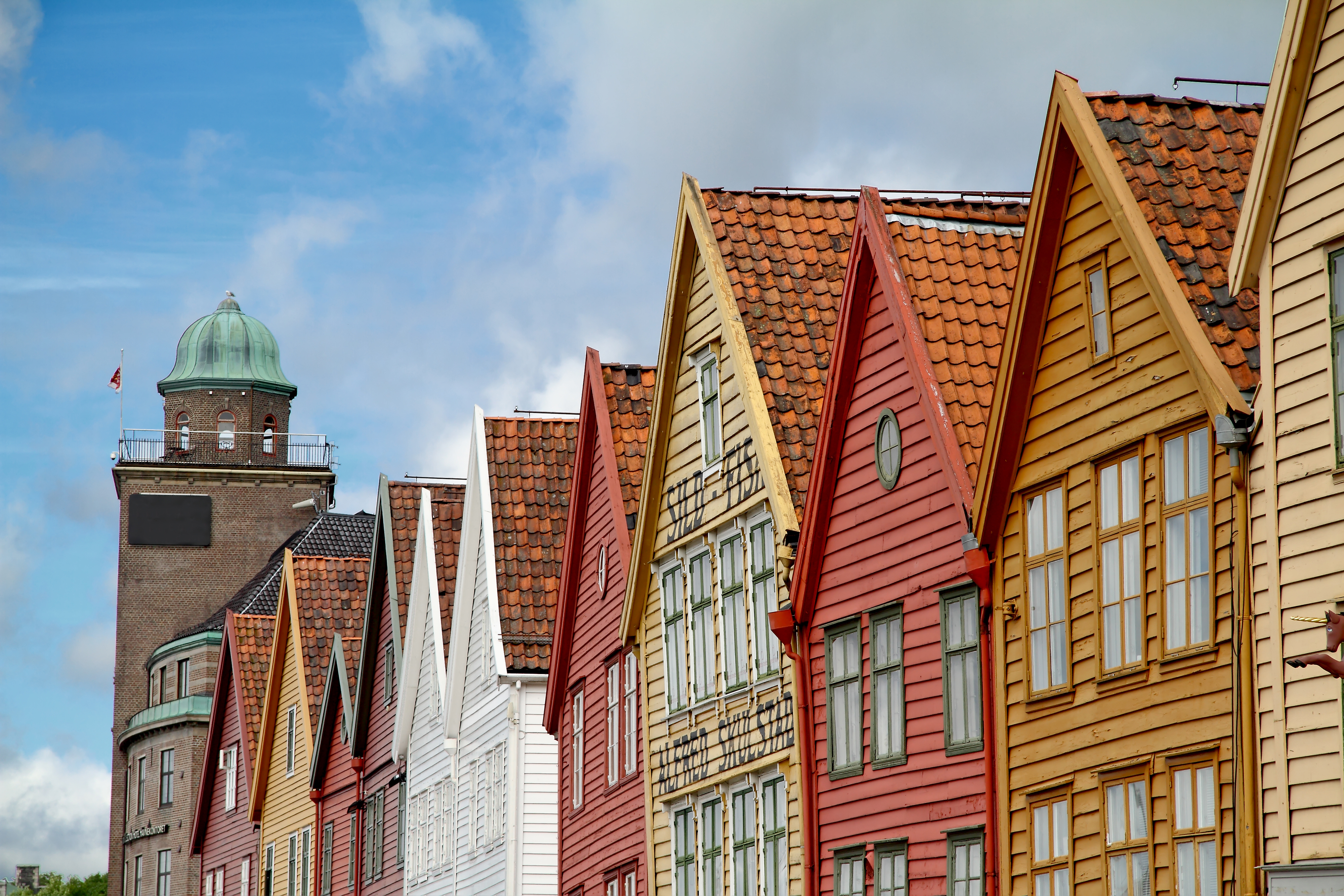Casas de madera con tejados rojos y al fondo una torre con cupula verde