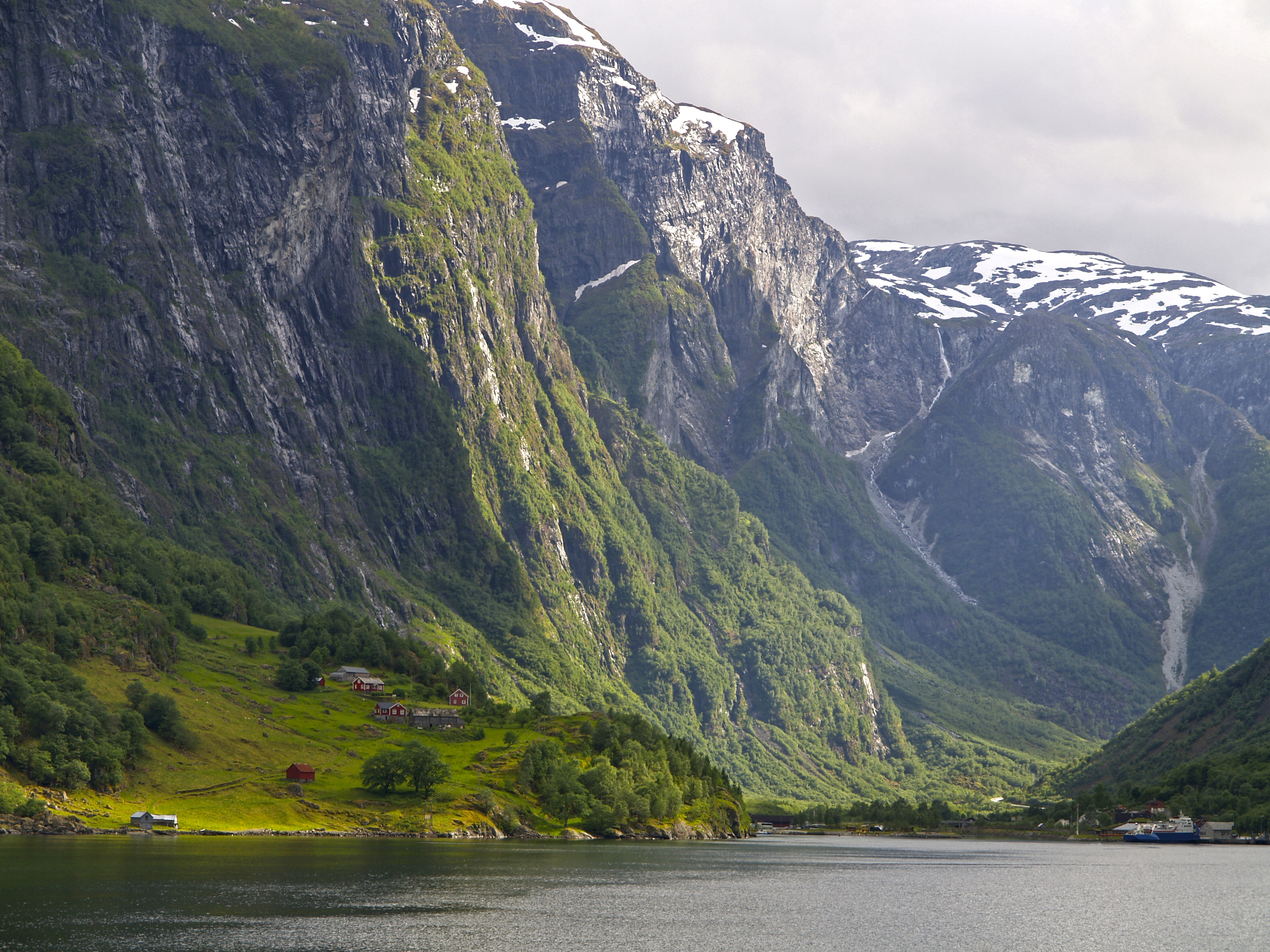 Altas montañas con casitas en la orilla del fiordo