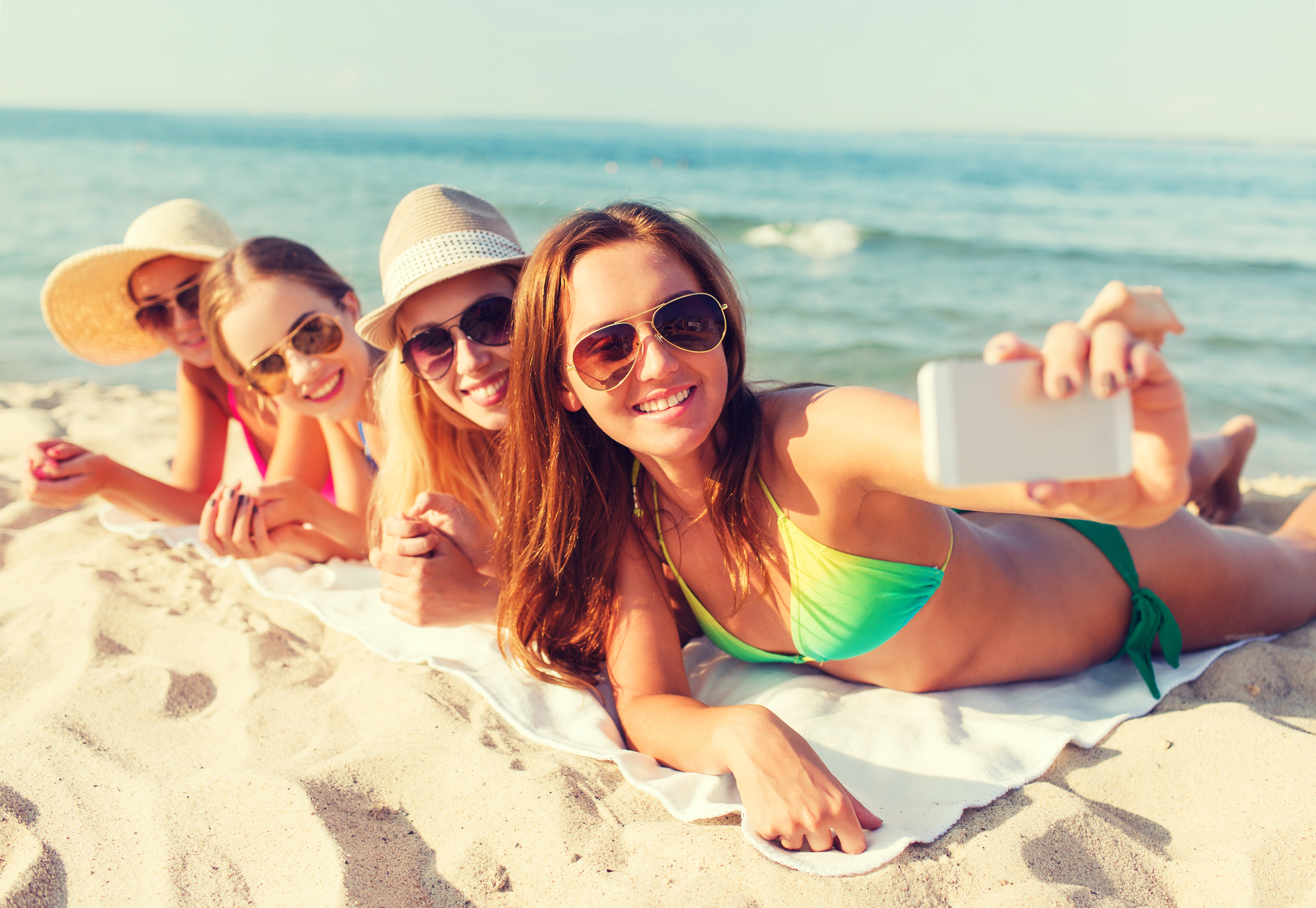 Amigas singles en la orilla del mar sonriendo