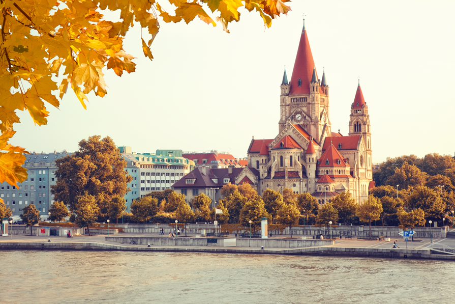 Preciosa iglesia con tejados rojos a orilla del Danubio en viena