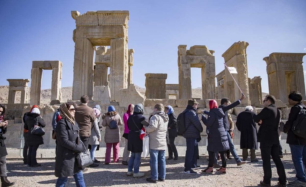 Grupo de personas muy abrigadas admirando unas ruinas