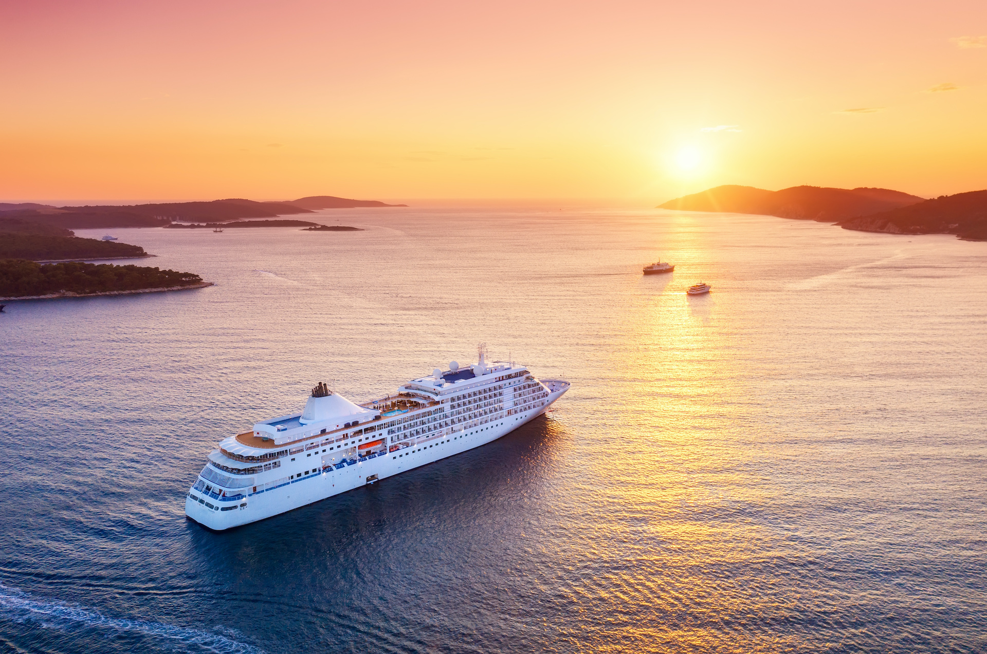 Crucero navegando entre islas al atardecer