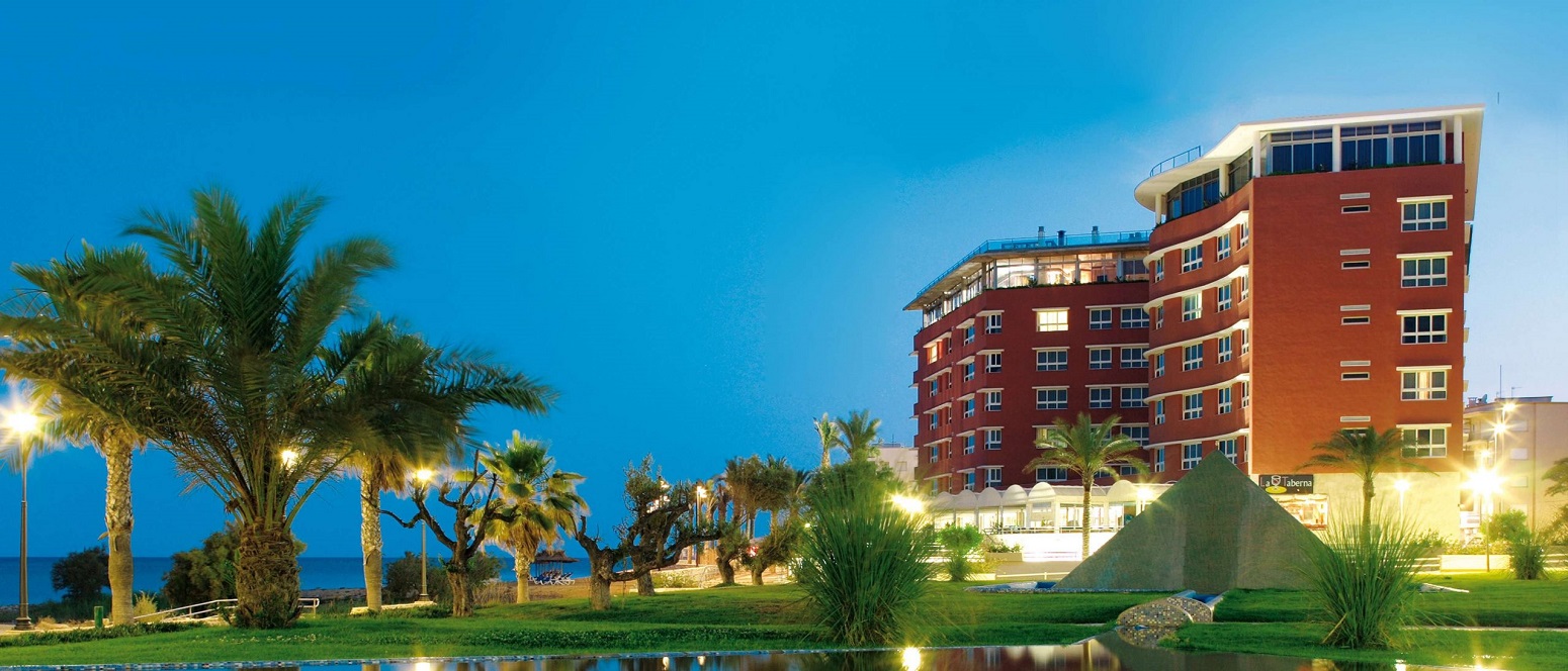 Panorámica de un hotel con palmeras y césped