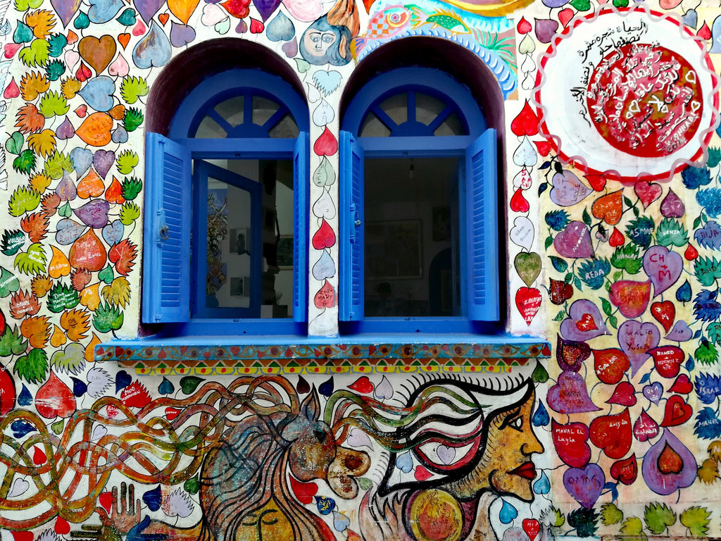 Ventanas típicas Marroquíes pintadas de azul en una fachada pintada con corazones
