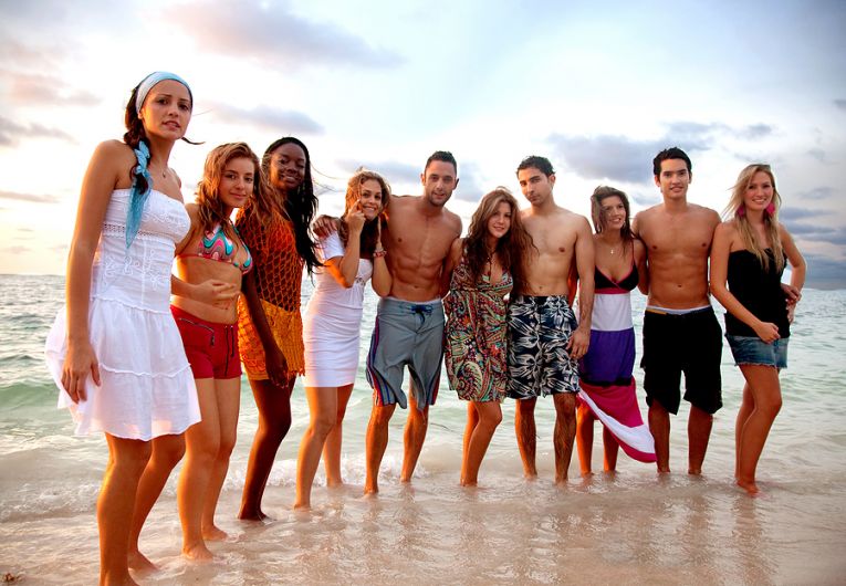 Grupo de jovenes en bañador a orillas del mar posando