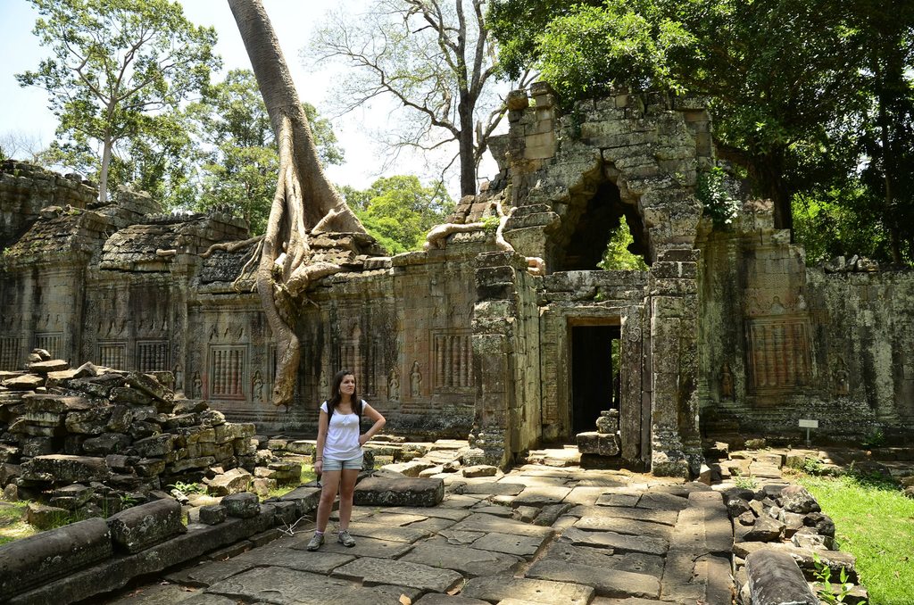 Turista admirando las ruinas de la antigua ciudad de Siem Reap tragadas por la selva