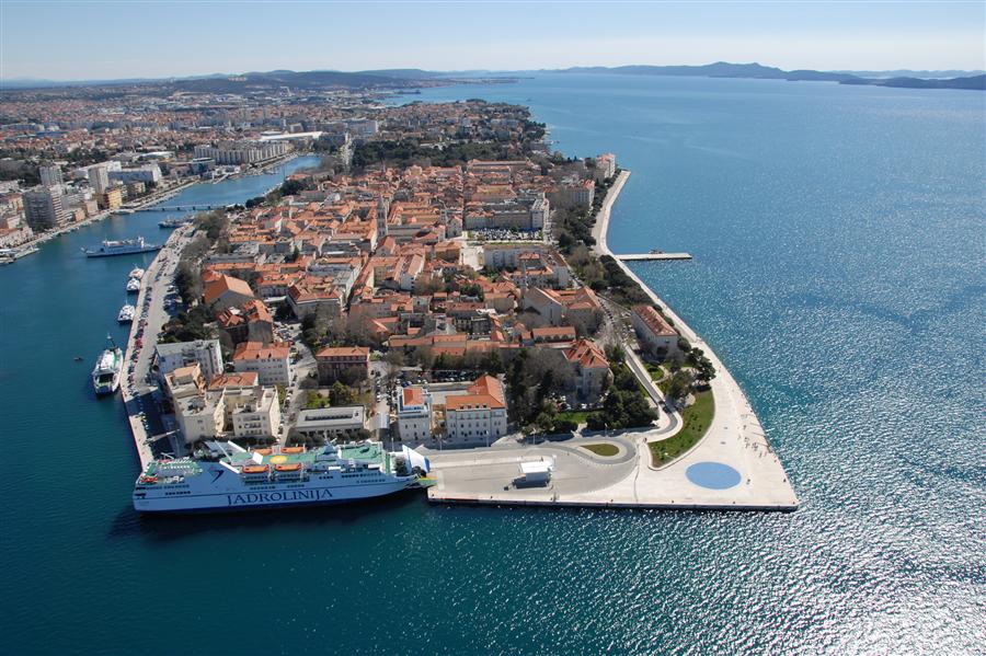 Panorámica de una ciudad rodeada de mar con tejados y casas antiguas
