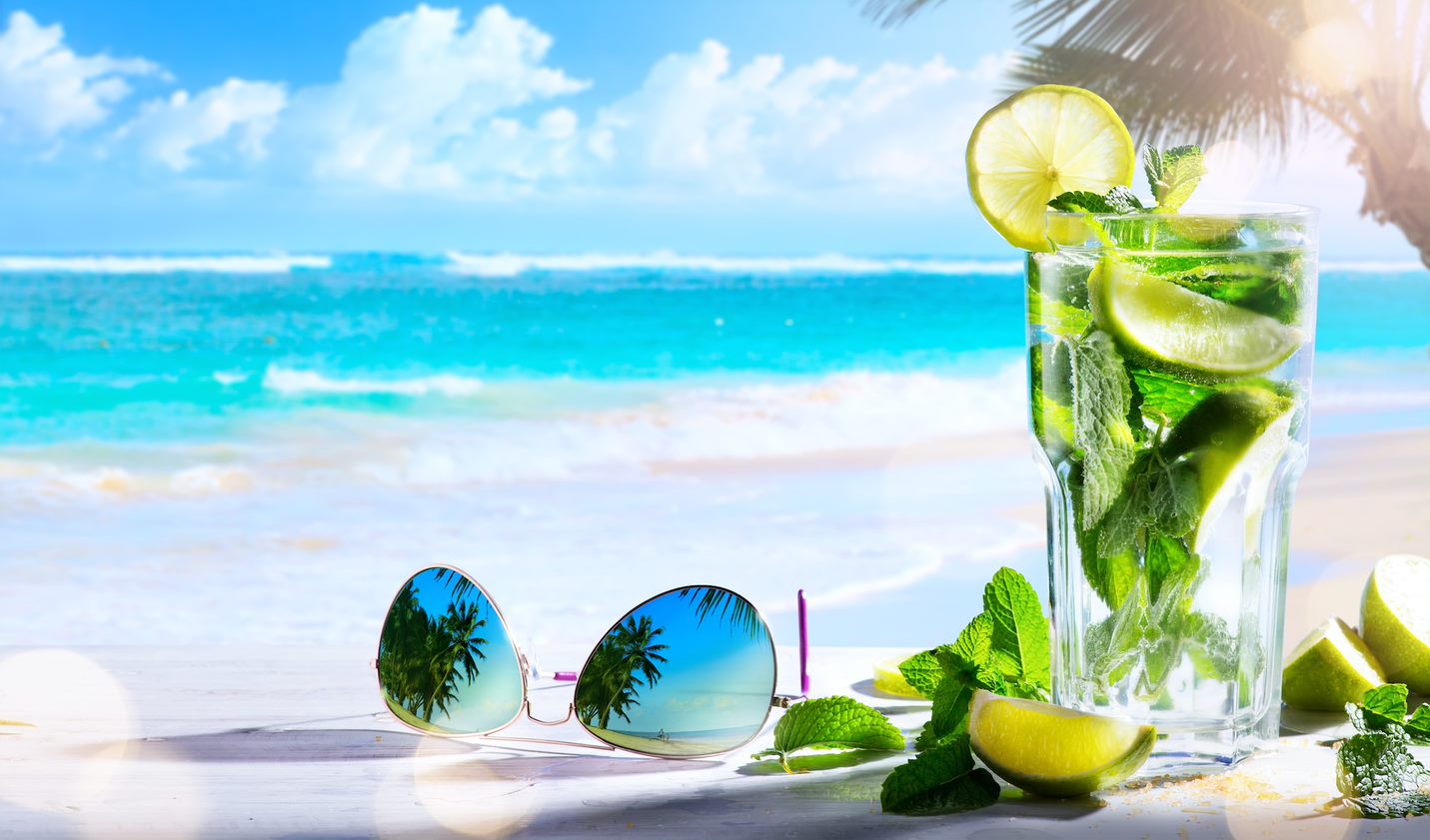Playa de arena blanca tomando una refrescante bebida al sol