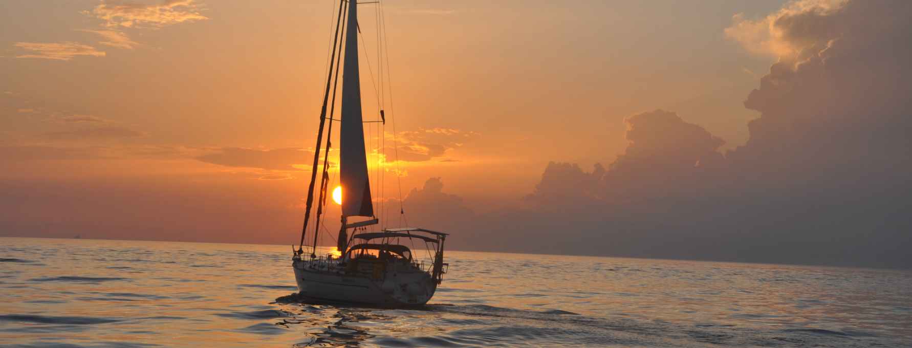 Velero navegando en un atardecer