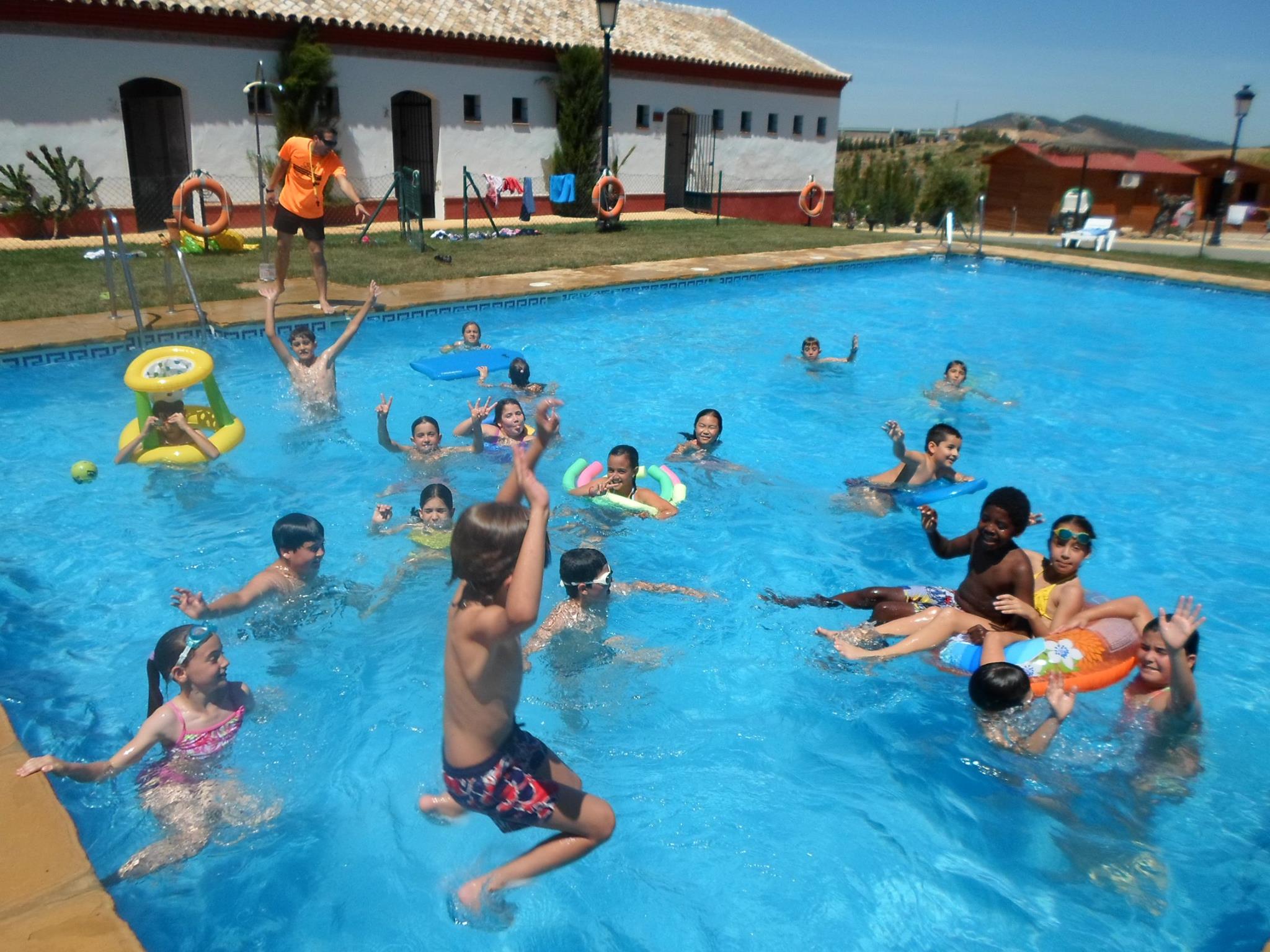 Niños y niñas en la piscina disfrutando del agua
