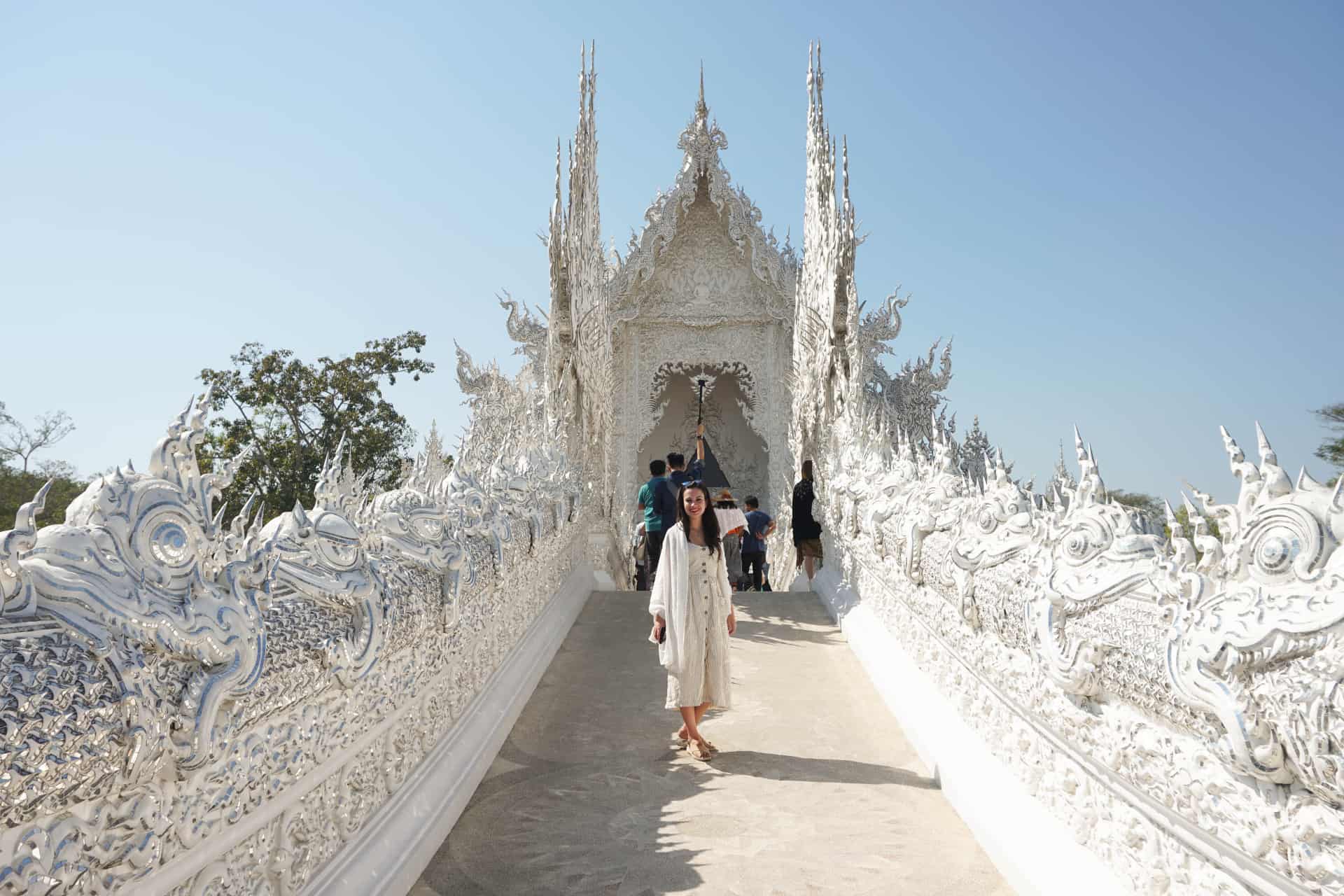 Mujer posando en un puente blanco a la entrada del templo